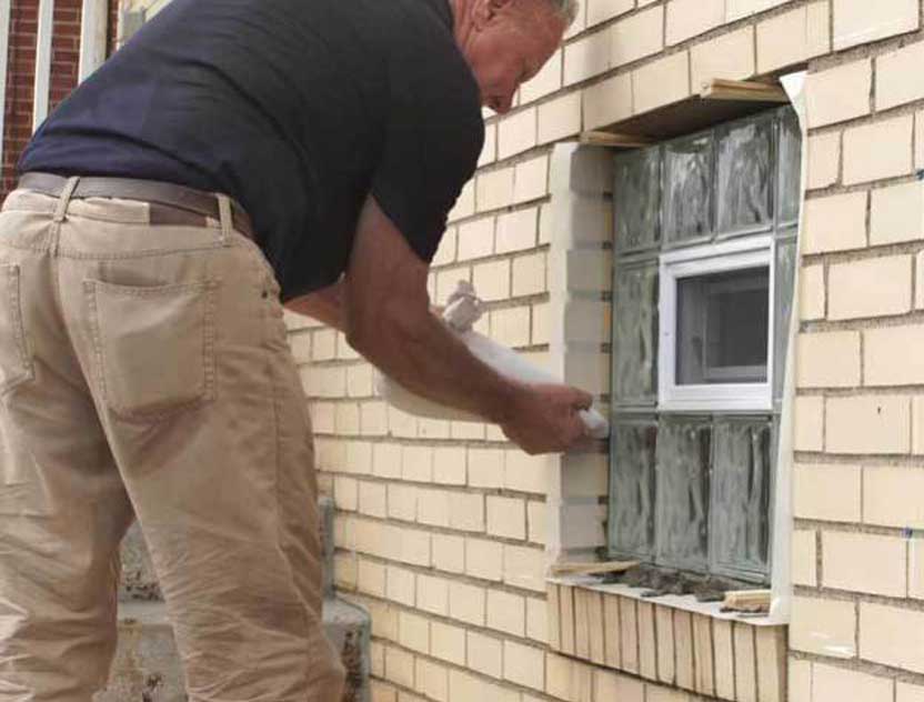 Glass Block Windows - This is a photo of an older gentleman installing a glass block basement window.